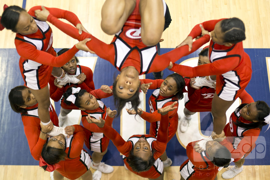 Cheerleaders warm up at the edge of the court before a game. This gym had a raised track that offered this great angle.