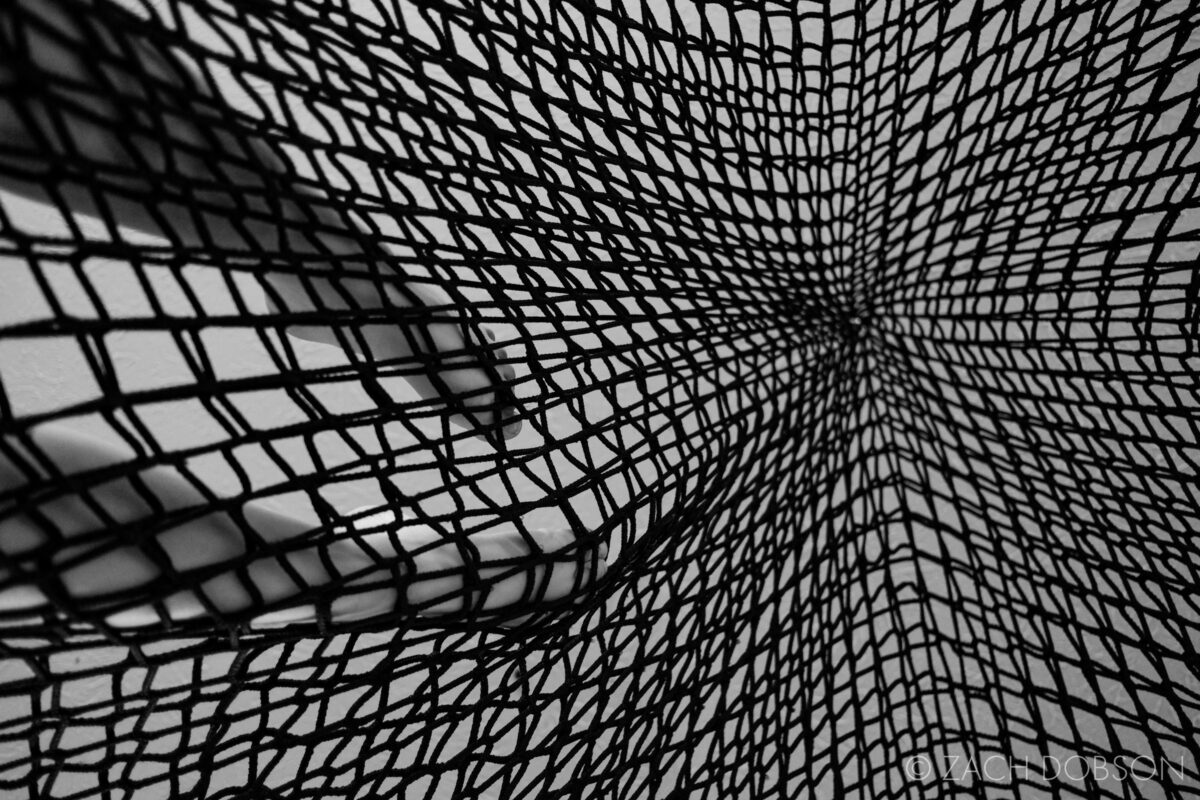 kid in climbing net in basement