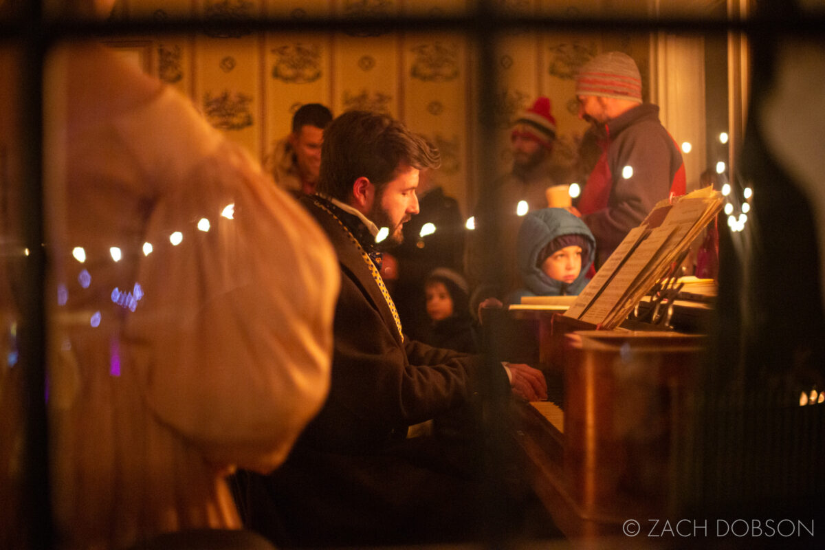 A Merry Prairie Holiday at Conner Prairie in Fishers, Indiana. Christmas soiree singing around the piano