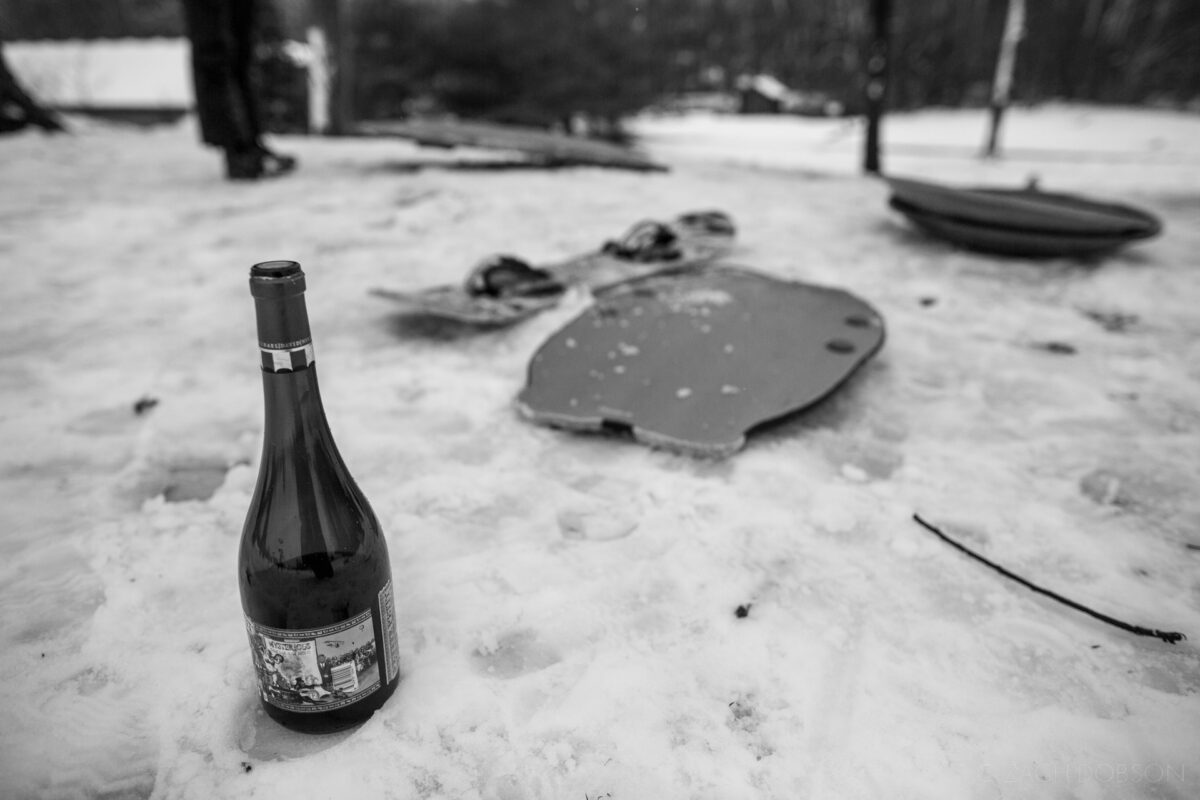 winter, sleds and wine bottle in the snow, carmel, indiana, black & white