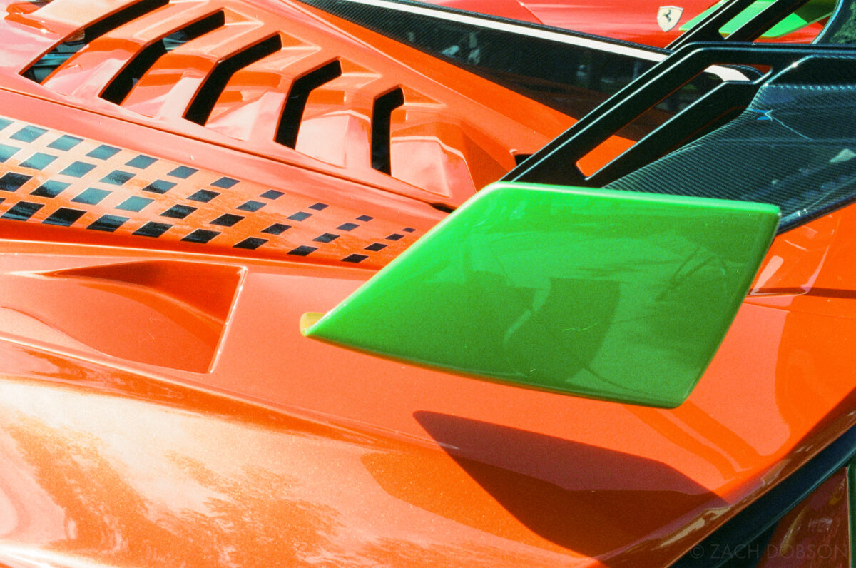 a bright orange detail photo of a Lamborghini with a neon green rear wing illustrates the importance of color photography