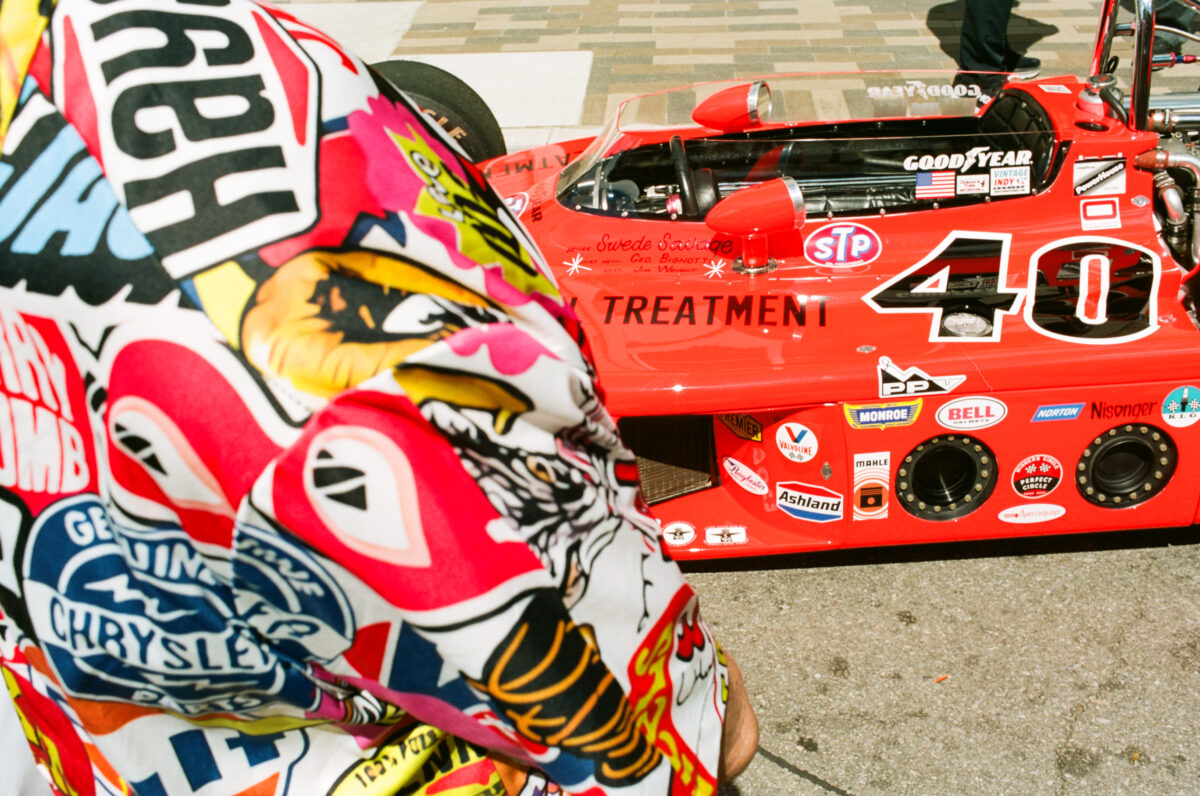 A neon orange red Indy Car from the 1970s at Carmel Artomobilia 2024