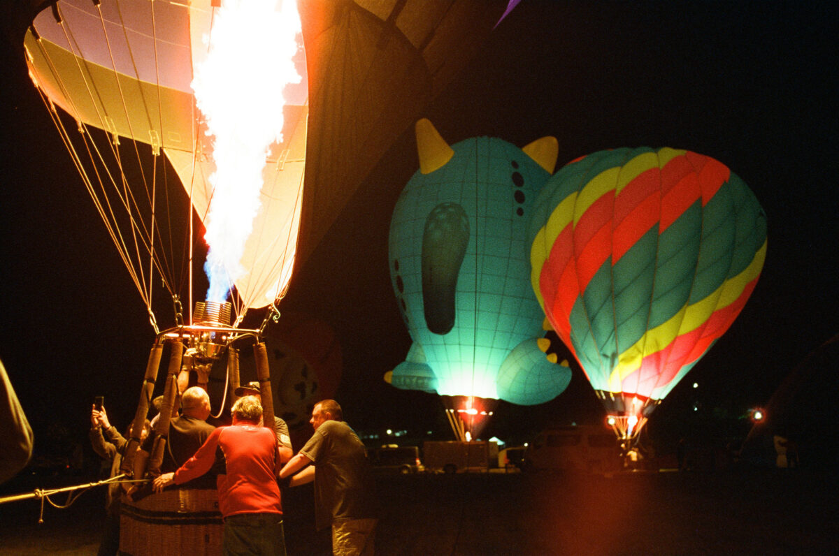 Colorful hot air balloons in the night. Photographing a Balloon Glow on film - Jupiter Flights Balloon Festival at Conner Prairie Image: Zach Dobson Photography