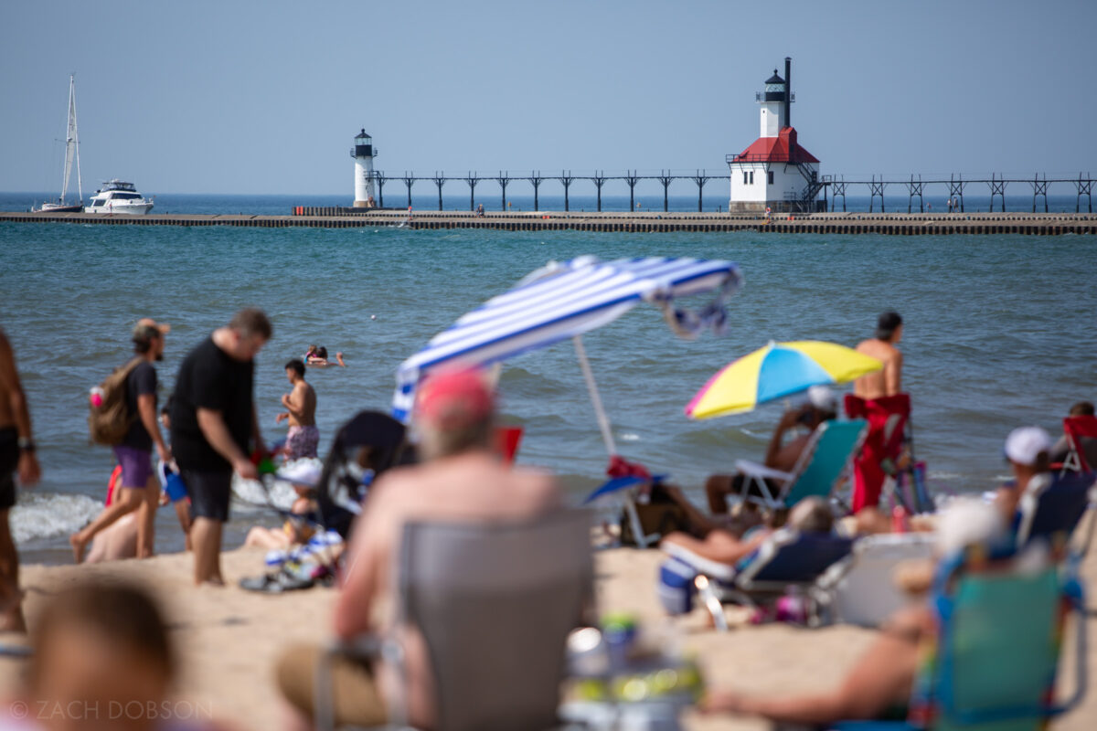 Swimming at sunset in Lake Michigan at Silver Beach in St. Joseph, Michigan with a view of the North Pier  inner & outer lighthouses