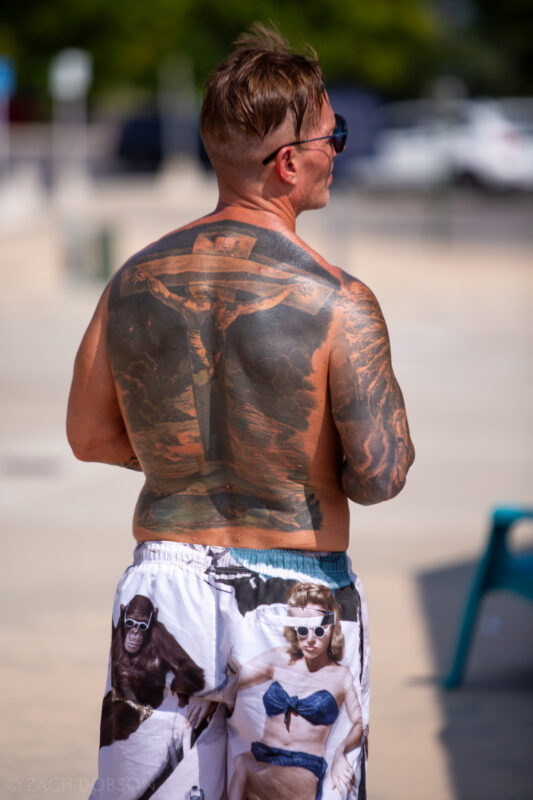 Crucifix back tattoo plus artistic board shorts.